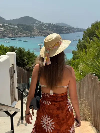 Jasmin mit Sonnenhut vor einer mediterranen Bucht